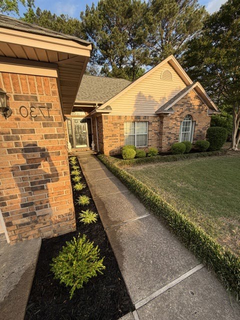 Same brick home after refreshed mulch beds and landscape edging